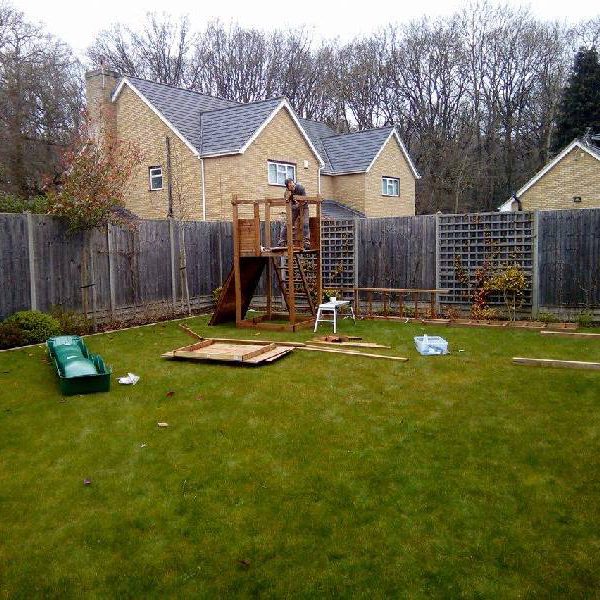 handyman building a Climbing frame with swing and slide set in garden
