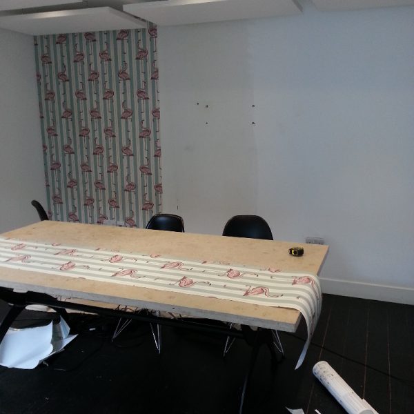 Office room with wall being wallpapered