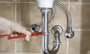 Image of sink waste pipe and plumber
