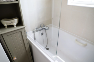 Image of a bathroom with bathtub shower screen and cabinet